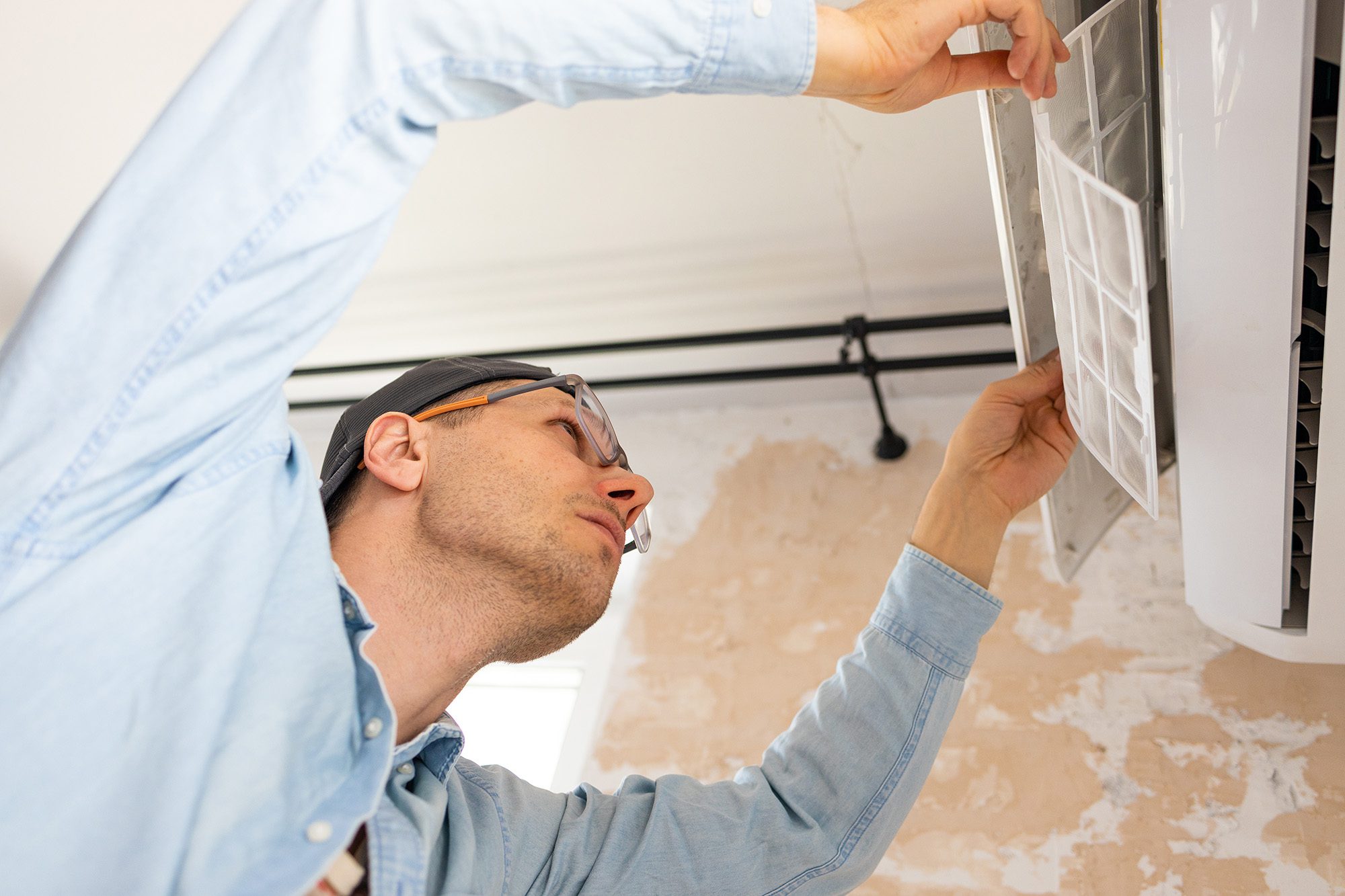 Technician inspecting a residential air conditioning system